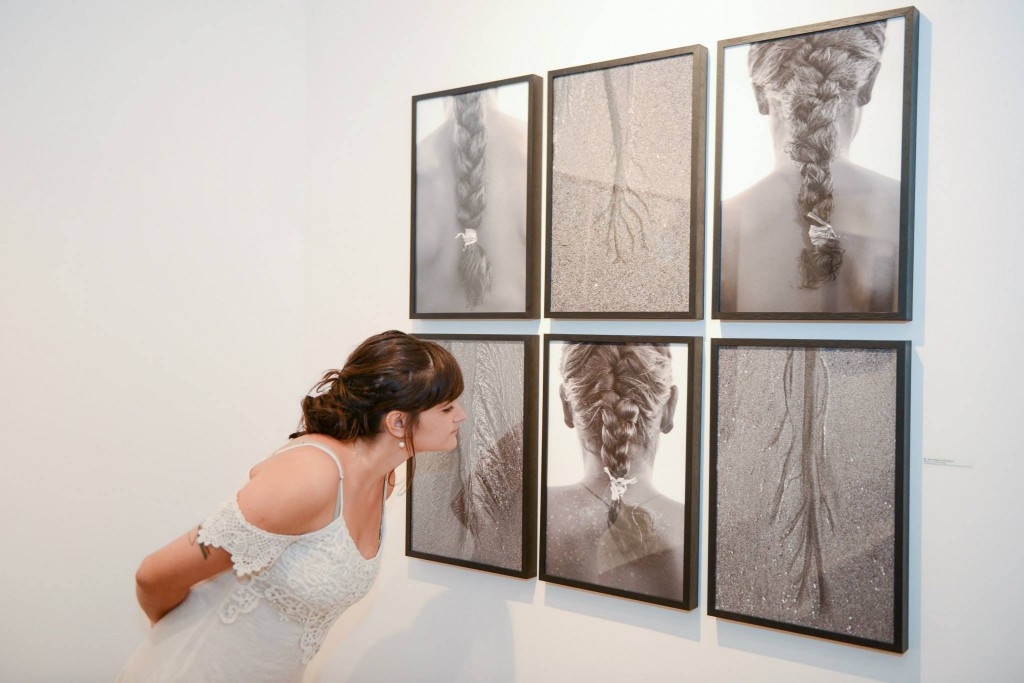 Natália Reis e fotos da exposição. Foto: Octopus Estúdio e Agência de Imagem.