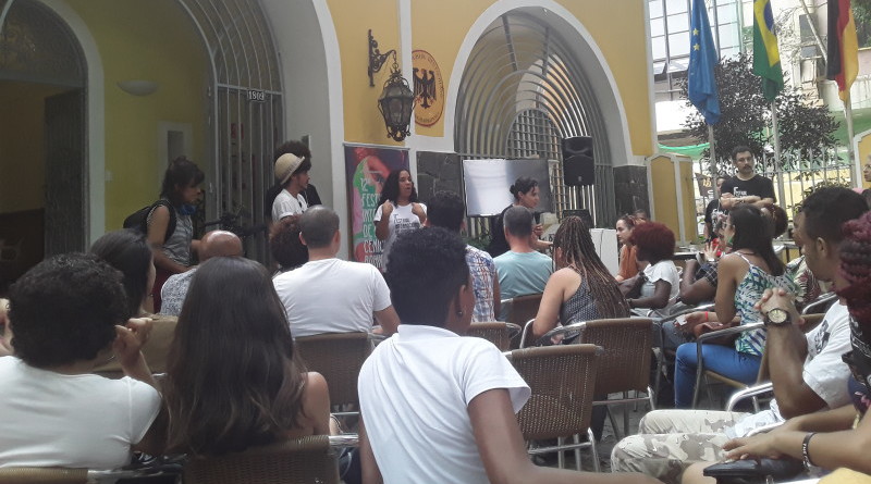 Um grupo de pessoas assiste a uma palestra na entrada do Goethe Institut